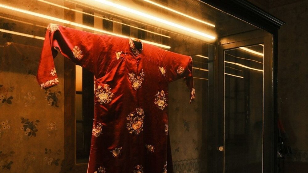 Túnica roja bordada expuesta en una vitrina de museo textil