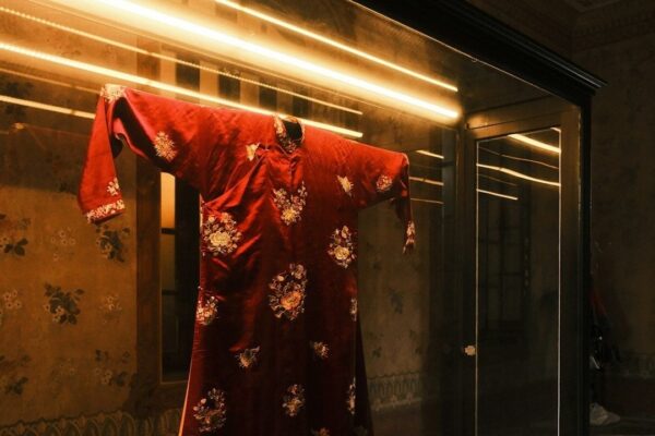 Túnica roja bordada expuesta en una vitrina de museo textil
